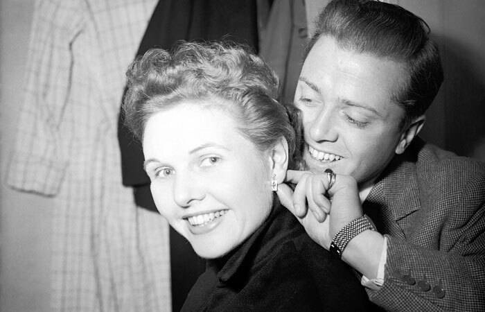 Sheila Sim receives earrings from her husband Richard Attenborough as a first-night present ahead of The Mousetrap opening at the Ambassadors Theatre, London, in 1952