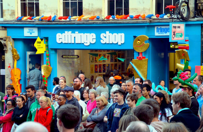 Crowds watching a street show outside the Edinburgh Fringe box office on the Royal Mile in 2018. Photo: Lou Armor/Shutterstock
