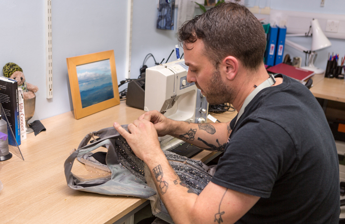 Ben Edmonds from the National Theatre repairing one of the costumes from Mirror Mirror. Photo: Lucy Barriball