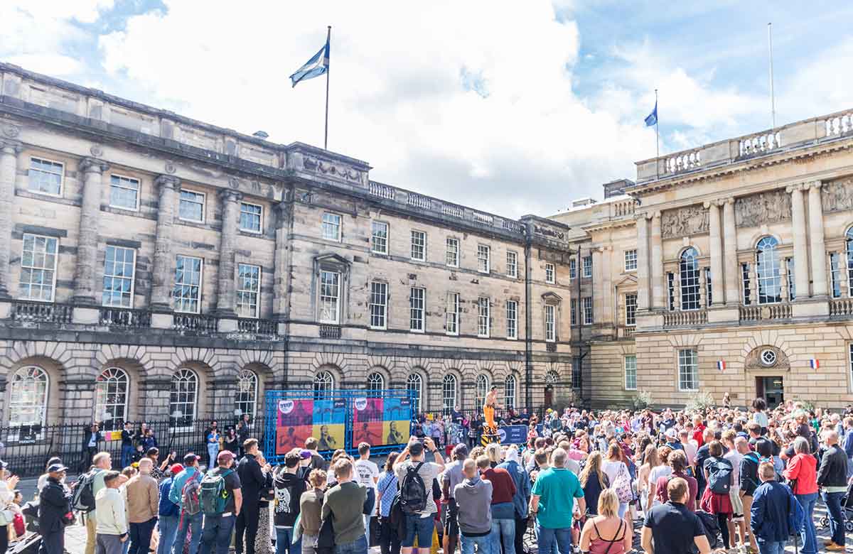 Crowds watch a street performance on the Royal Mile during the Edinburgh Festival Fringe 2022. Photo: Shutterstock